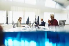 Two women and a man are working on their desk